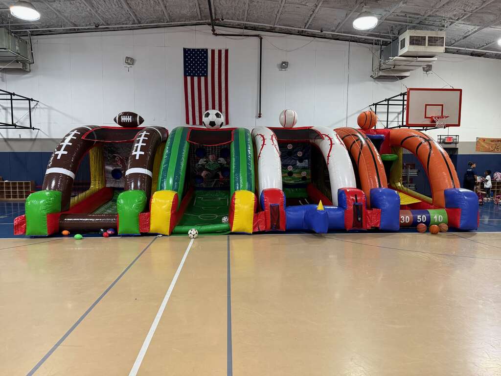Interactive sports games lined up inside a school gym for an organized event