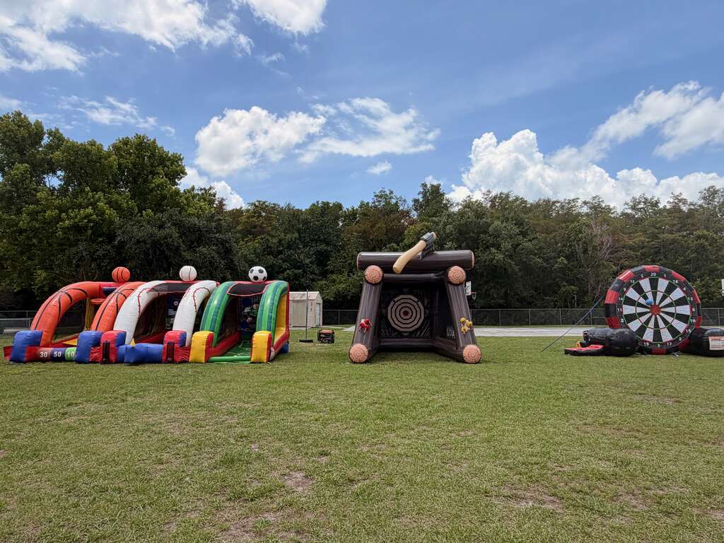 Sports-themed interactive inflatable games lined up for an outdoor event