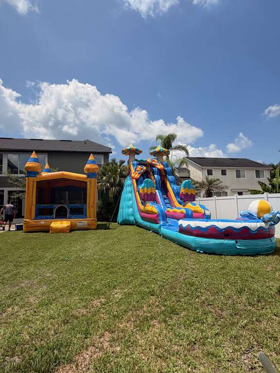 Bounce house and water slide combination rentals set up for a family event