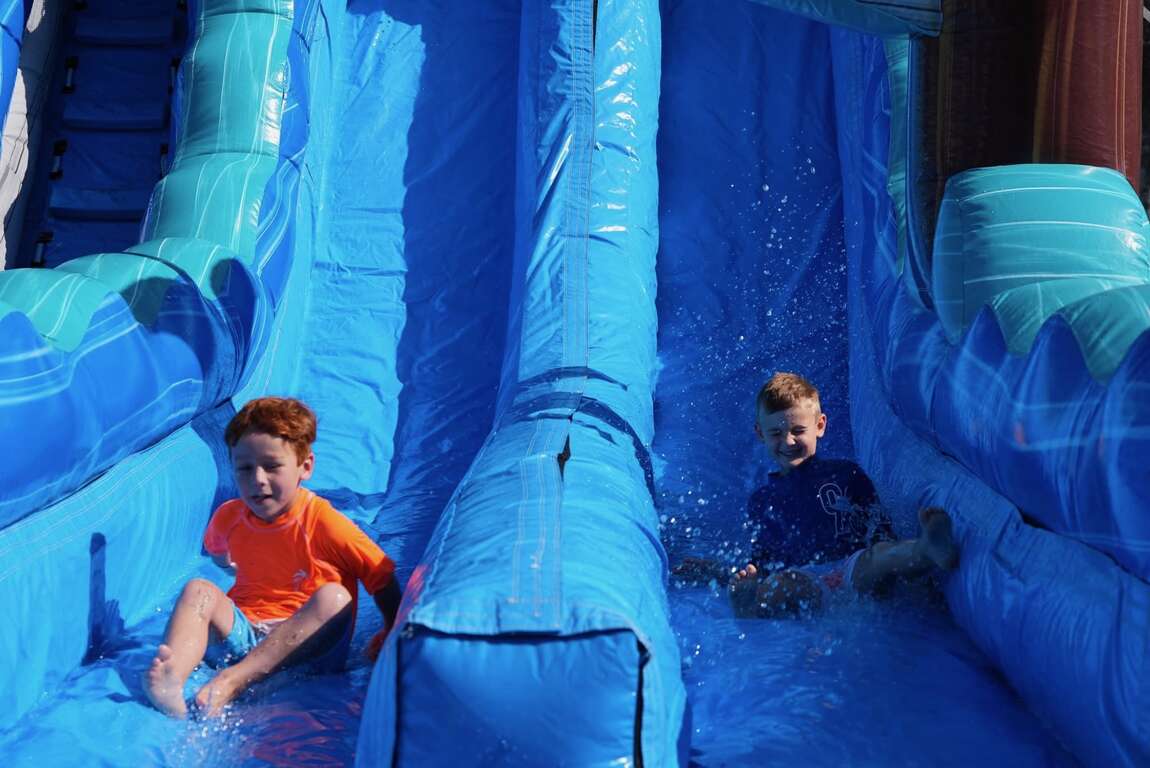 Children enjoying a large blue inflatable water slide