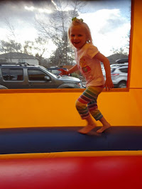 Little girl smiling while she plays in the bouncy house.