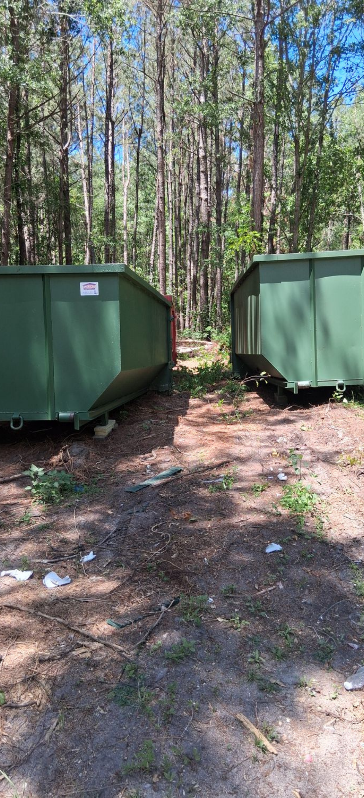 green dumpsters placed in wooded area green dumpsters placed in wooded area