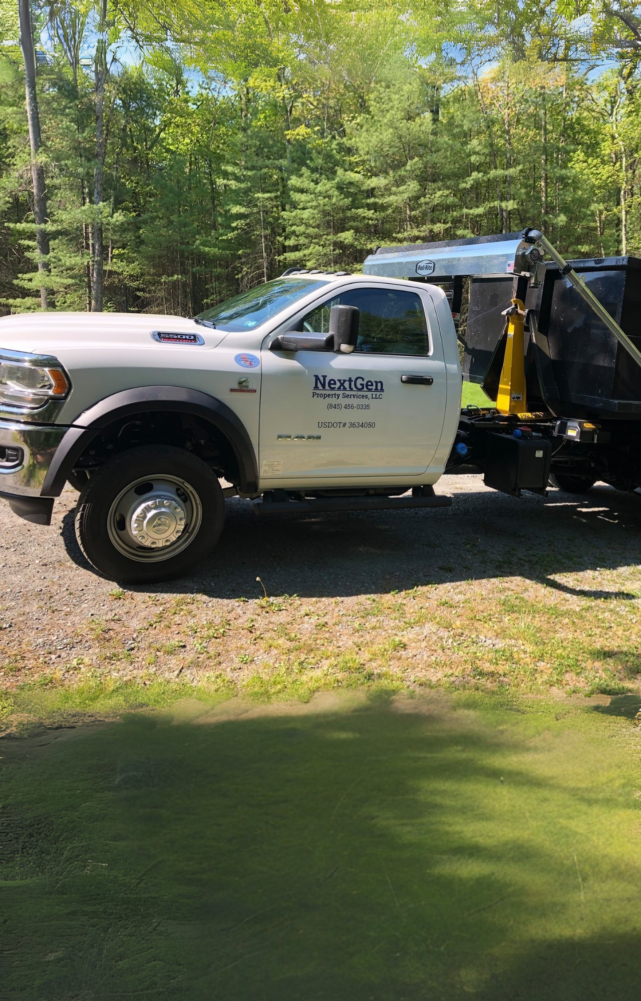 NextGen Property Services white RAM truck hauling black dumpster NextGen Property Services white RAM truck hauling black dumpster