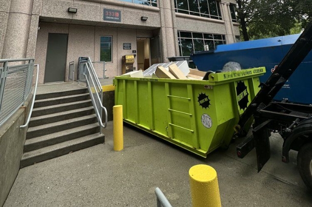 Roll-off dumpster from North Point Dumpsters filled with construction debris at a commercial building entrance