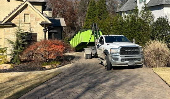 North Point Dumpsters truck delivering a lime-green roll-off container to an upscale residential property