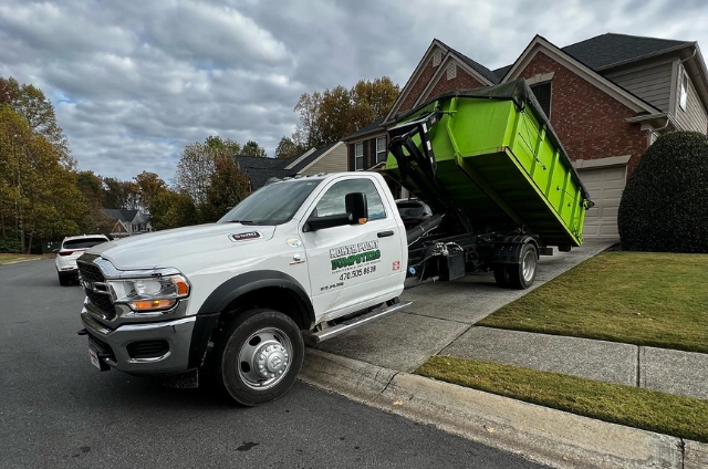 North Point Dumpsters  truck delivering a lime-green roll-off container to a residential neighborhood