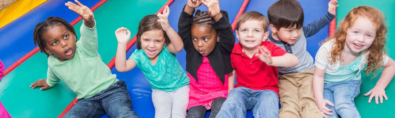 Kids jumping and playing on a colorful inflatable obstacle course for the Bounce House Rentals 101 Miami guide