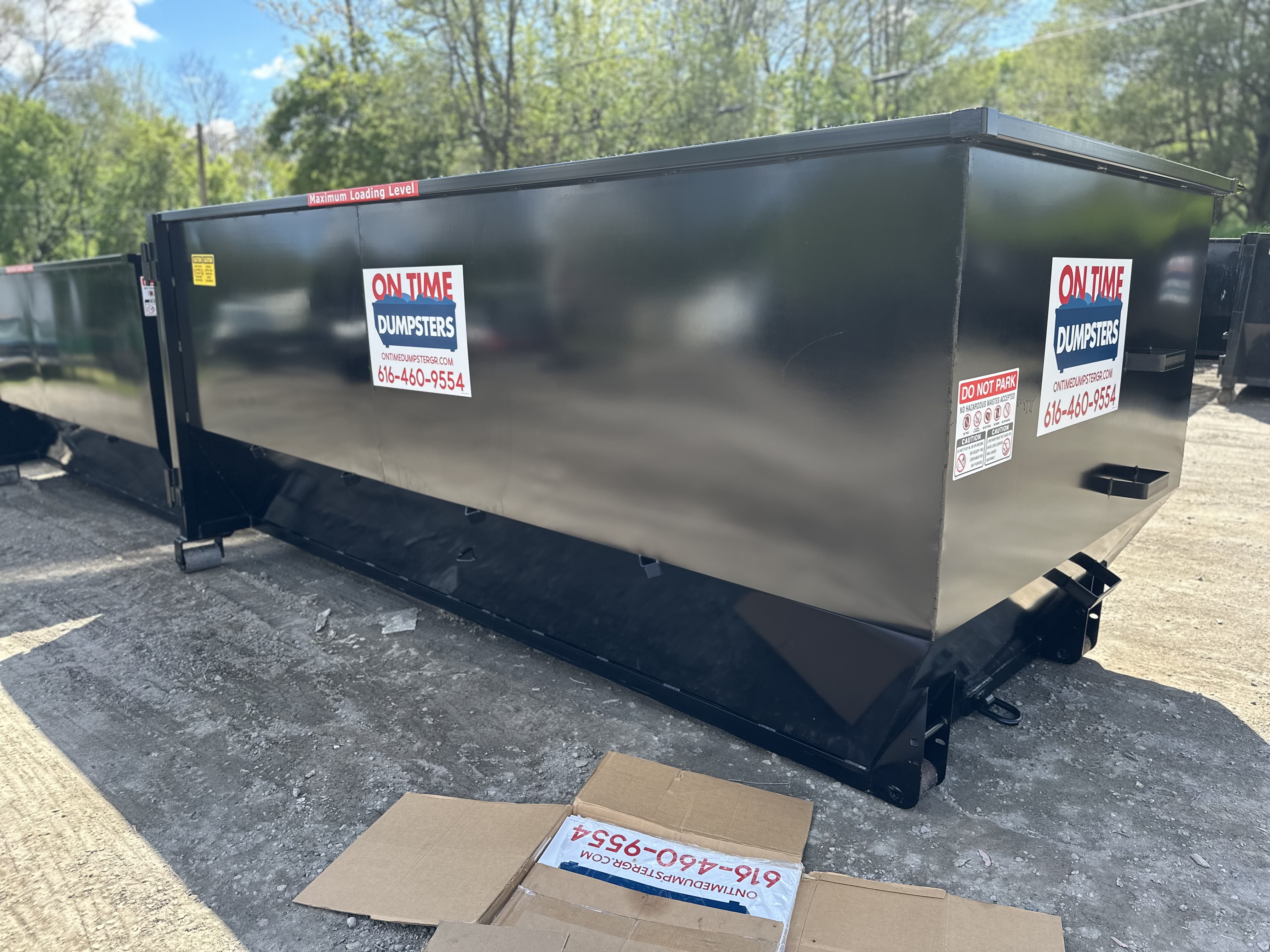 Black dumpster in residential driveway Black dumpster in residential driveway