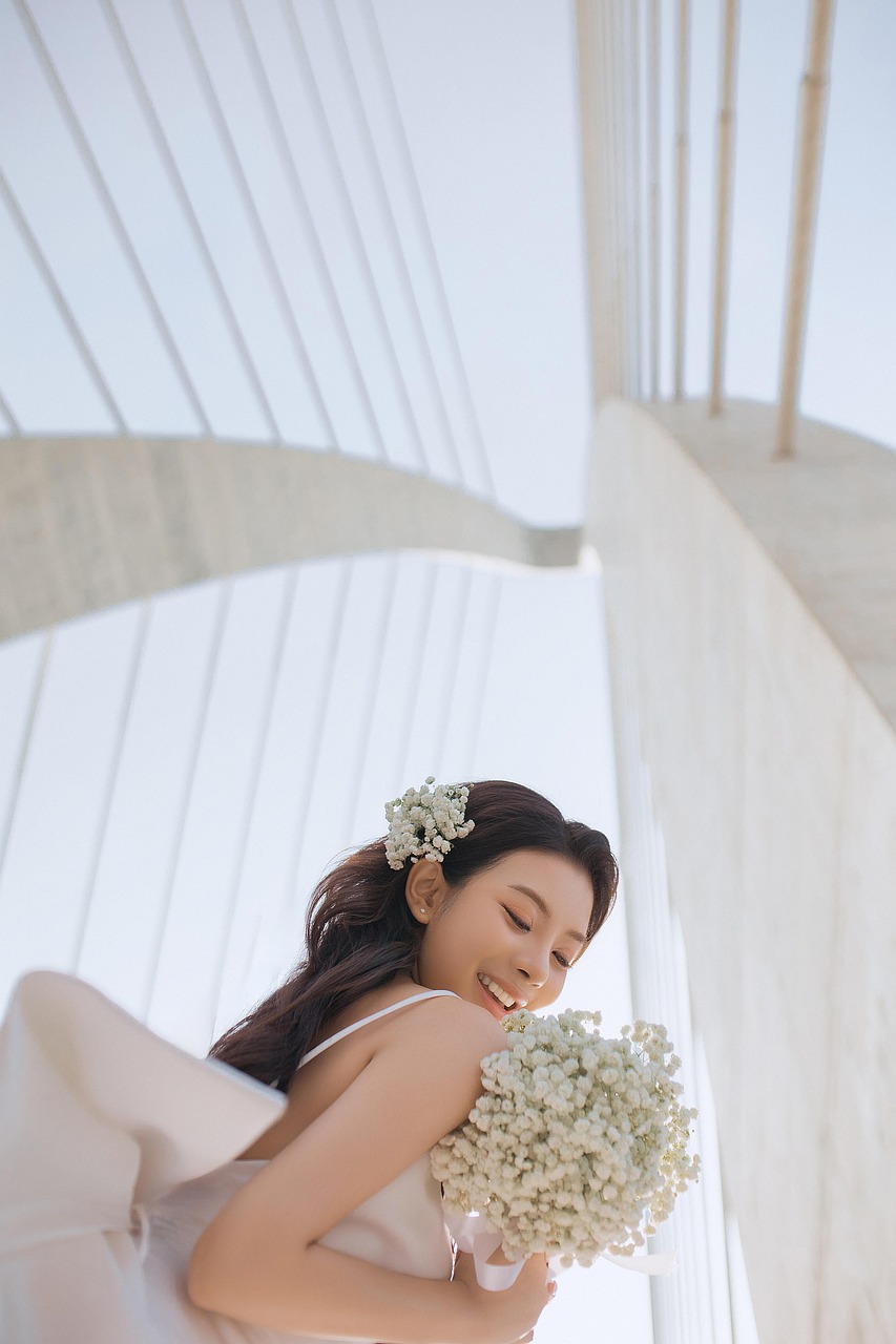 Smiling bride in an elegant wedding dress standing outdoors