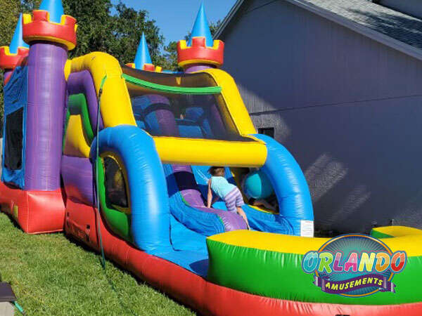 Orlando Amusements castle bounce house slide with child.