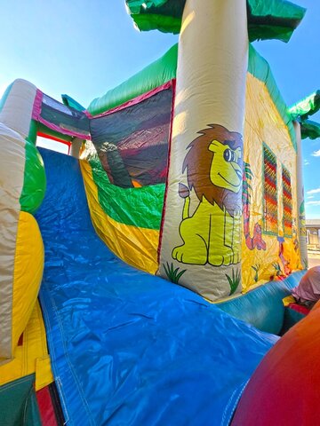 kids-playing-in-a-lion-themed-jungle-bounce-house-with-tropical