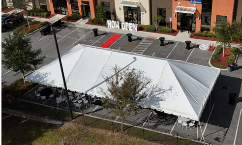 Tent and bounce house rental set up on a lawn by Orlando Fun Bounce.