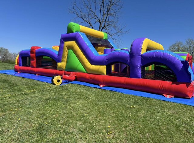40-foot rainbow obstacle course rental displayed at an outdoor event in Berea, SC, offering a fun mix of climbing challenges, tunnels, and bright inflatable features.