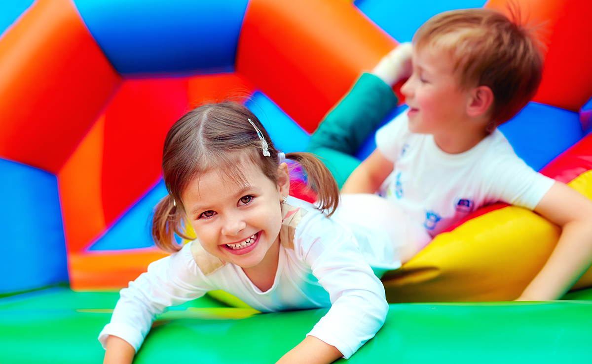 Two young children having fun inside a bounce house during a party in Greenville, SC – Bounce House Rentals from Party To Go