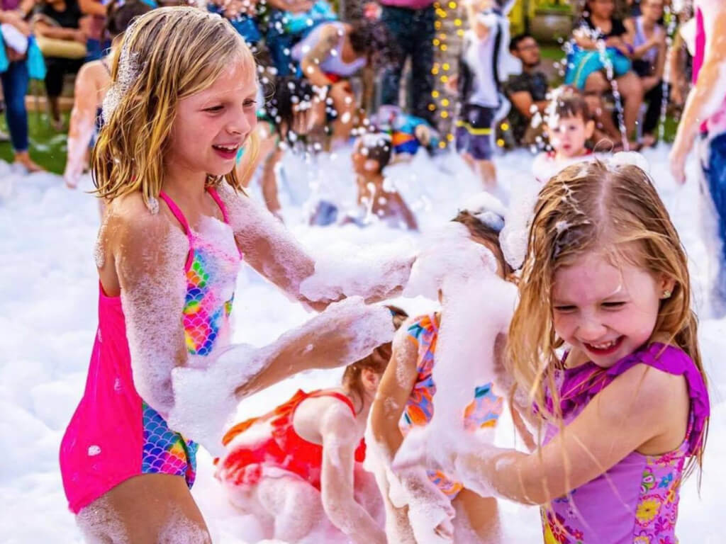 Children splashing and playing in foam at a family-friendly event in Parker, SC. Children splashing and playing in foam at a family-friendly event in Parker, SC.