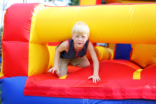 Young boy crawling through a colorful inflatable obstacle course in Simpsonville, SC.