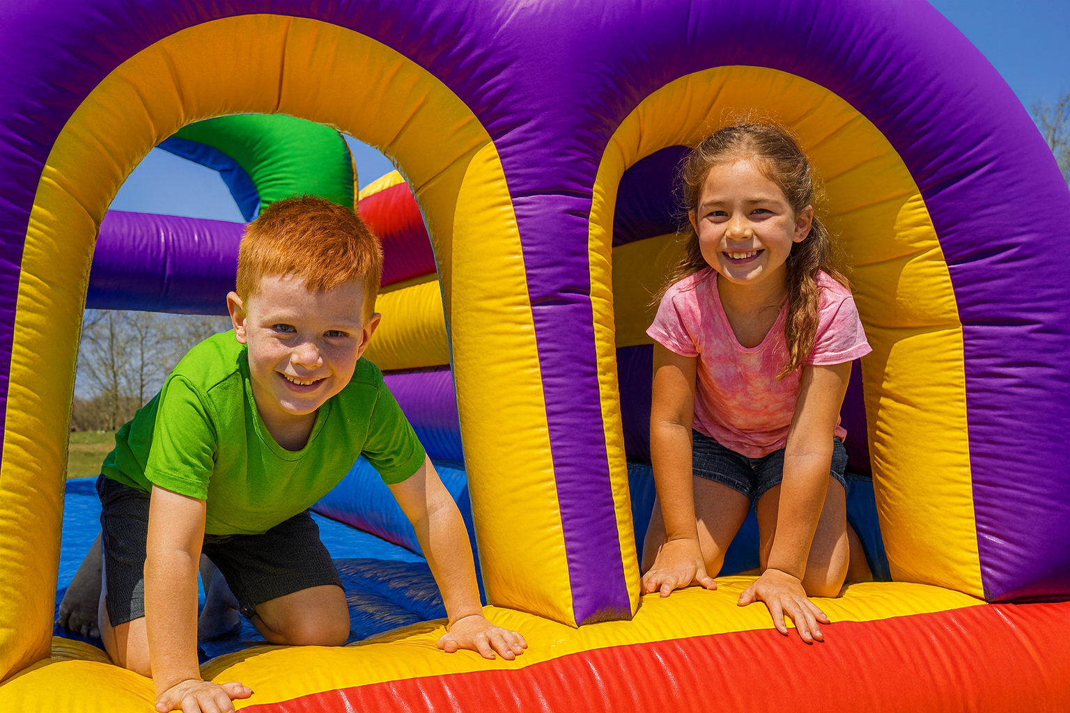 Two kids playing inside a colorful inflatable obstacle course during a sunny outdoor party in Simpsonville, SC.
