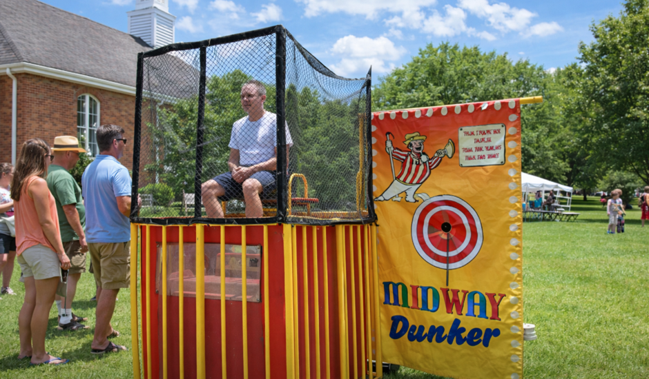 Yellow carnival dunk tank rental at a church picnic in Piedmont, SC with adults gathered around during a sunny outdoor community event.