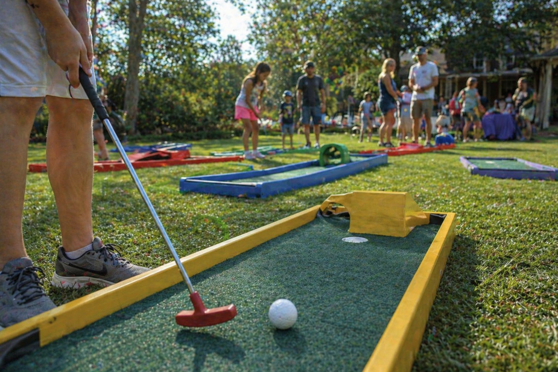 Portable mini golf rentals in Taylors, SC set up at an HOA community event with families enjoying multiple colorful putting lanes. Mini golf rentals in Taylors, South Carolina are a great option for neighborhood gatherings, corporate picnics, and local festivals. This clean and professionally arranged course adds fun for all ages.