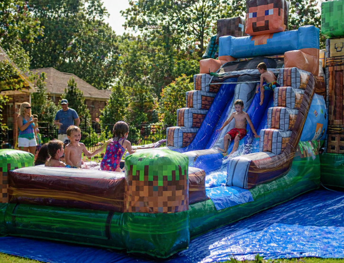 Children playing on a Minecraft-themed inflatable water slide rental at a sunny backyard party in Greenville, SC. Realistic summer party scene with kids splashing, climbing, and sliding while parents supervise, showcasing last-minute party rentals for May and early summer events in Greenville.