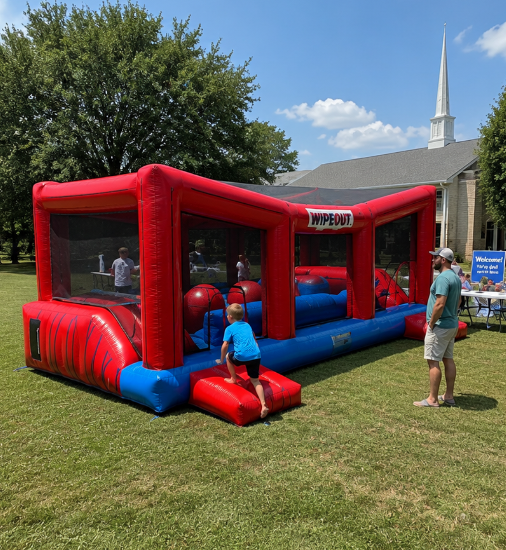 Red and blue Wipeout inflatable obstacle game at an outdoor event in Travelers Rest, SC, with a child entering the attraction.