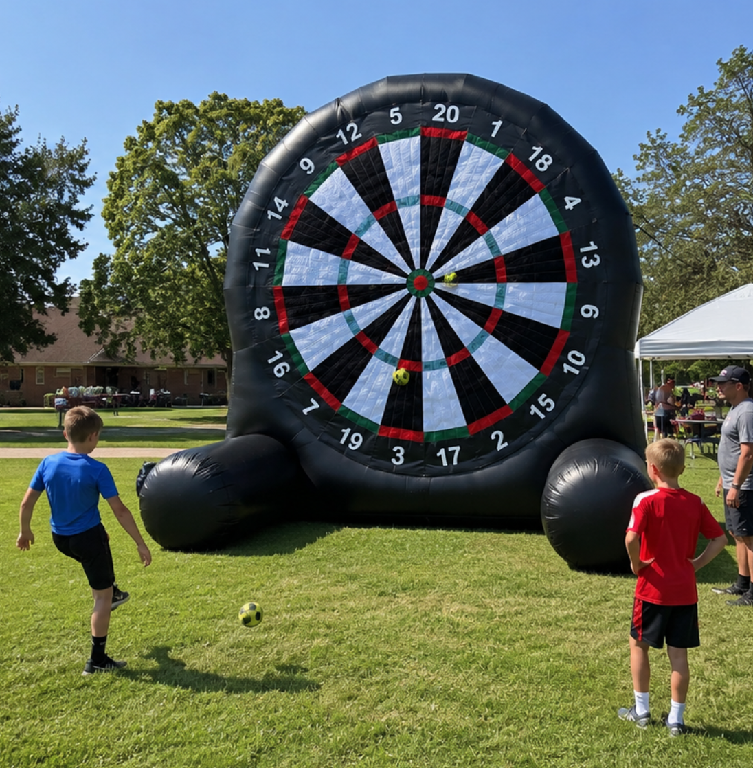 Giant inflatable dartboard game on a grassy event field in Taylors, SC, with children taking turns playing.