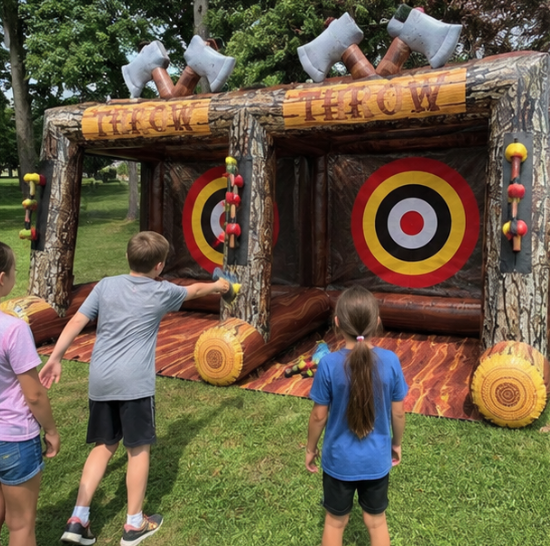 Children taking turns at a dual-lane inflatable axe throwing game with colorful targets.