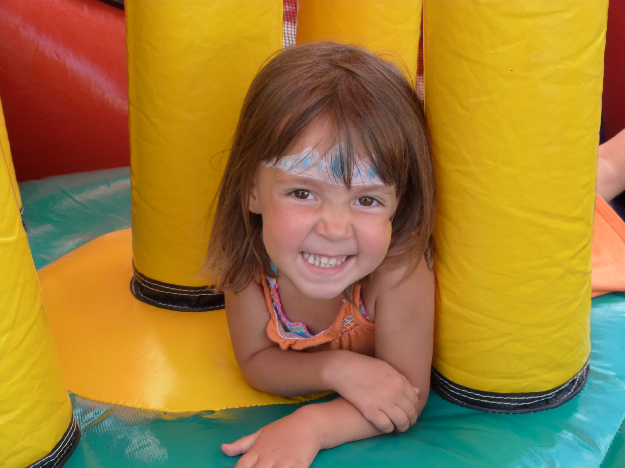 Happy child playing inside a colorful bounce house during a Halloween party in Greenville, SC