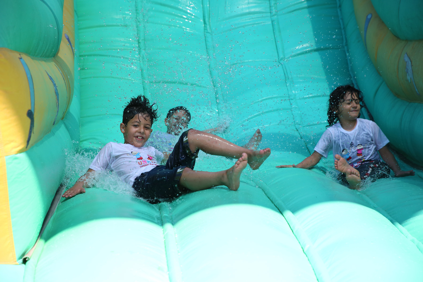 Children enjoying a colorful inflatable slide during a community event, highlighting Water Slide Rentals in Taylors, SC for family-friendly summer fun.