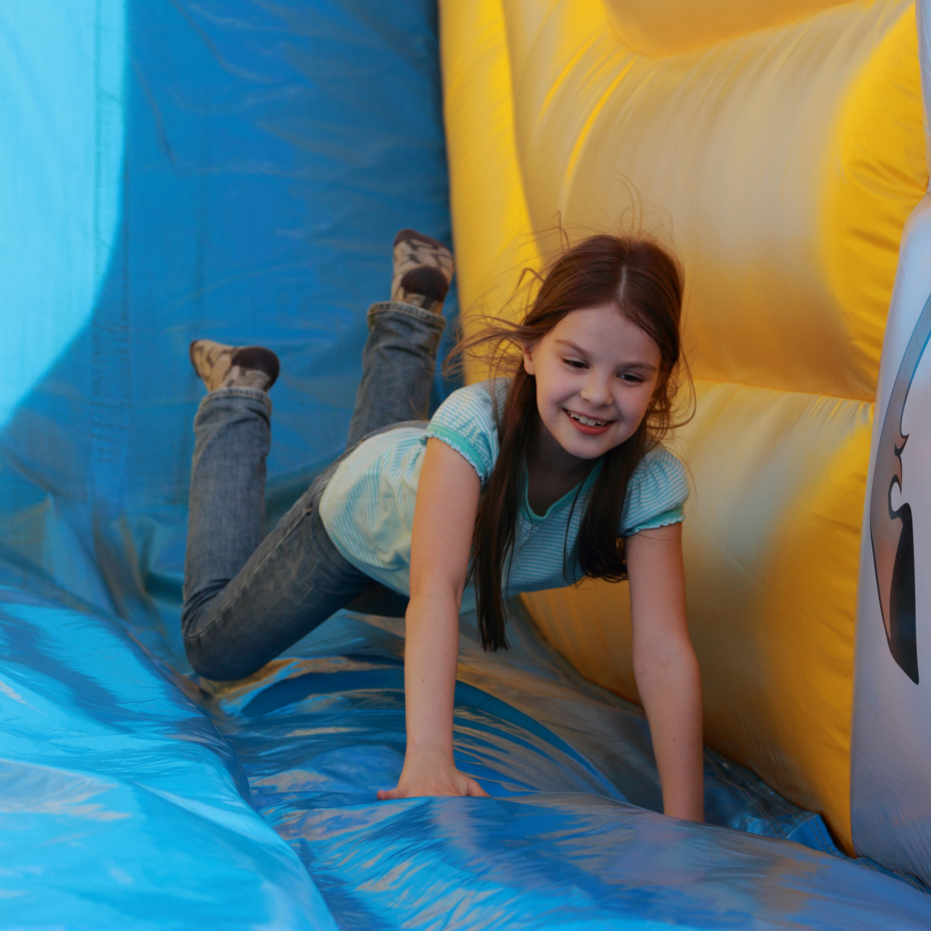 Child crawling through a colorful inflatable obstacle course at a party in Berea, SC, featuring soft padded surfaces and bright, kid-friendly design.