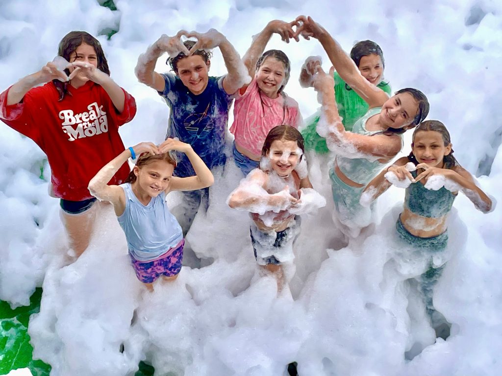 Smiling child covered in bubbles wearing sunglasses at a fun-filled foam party in Travelers Rest, SC. Smiling child covered in bubbles wearing sunglasses at a fun-filled foam party in Travelers Rest, SC.
