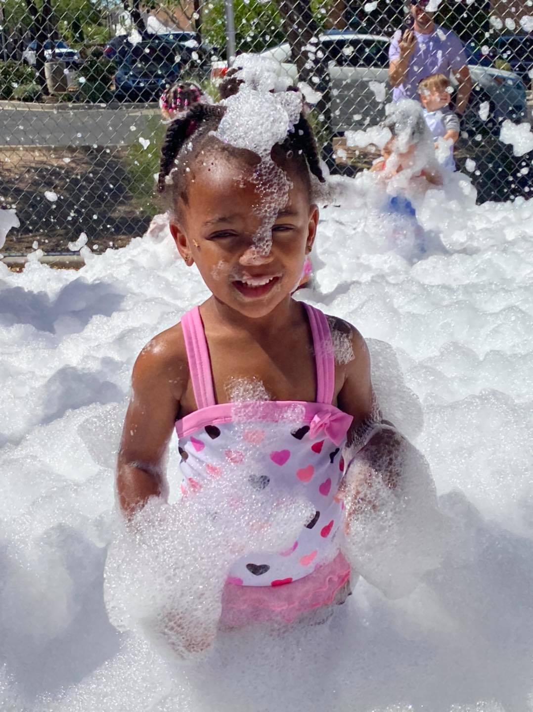 A little girl in a heart-pattern swimsuit having fun in the bubbles at a foam party in Mauldin, SC. A little girl in a heart-pattern swimsuit having fun in the bubbles at a foam party in Mauldin, SC.