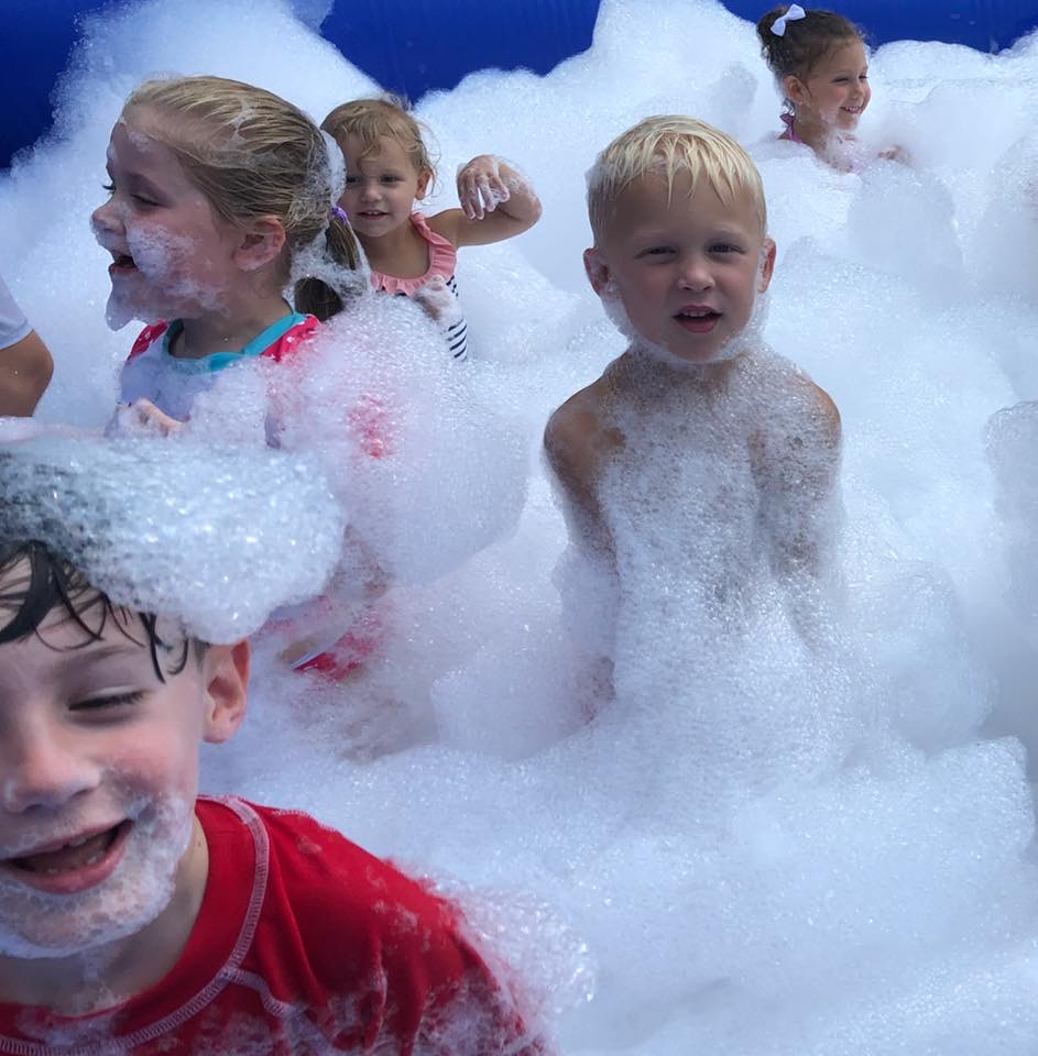 Children laughing and covered in bubbles during a lively foam party in Gantt, SC. Children laughing and covered in bubbles during a lively foam party in Gantt, SC.
