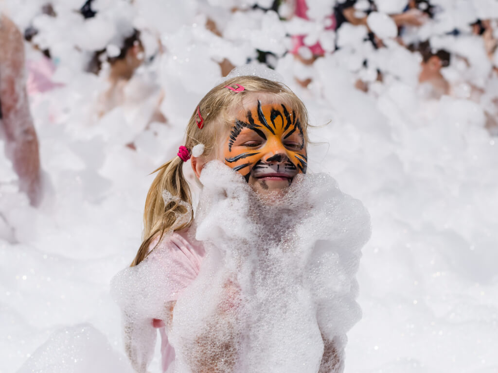 Little girl with face paint smiling and covered in foam at a community event in Parker, SC. Little girl with face paint smiling and covered in foam at a community event in Parker, SC.