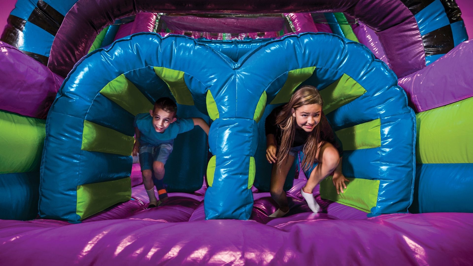 Kids enjoying an outdoor inflatable obstacle course in Greenville, SC, perfect for November events, fall festivals, and cooler weather party rentals