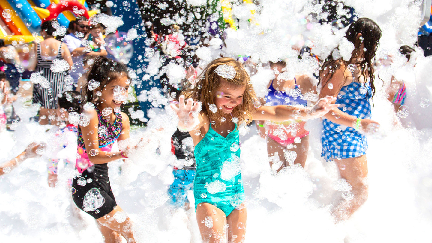 Children running through foam sprayed by a high-output foam machine at a community event in Piedmont SC.