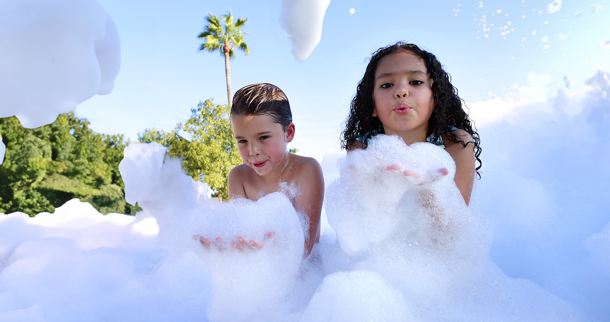 Children playing with bubbles created by a party foam machine during an outdoor gathering in Piedmont SC.
