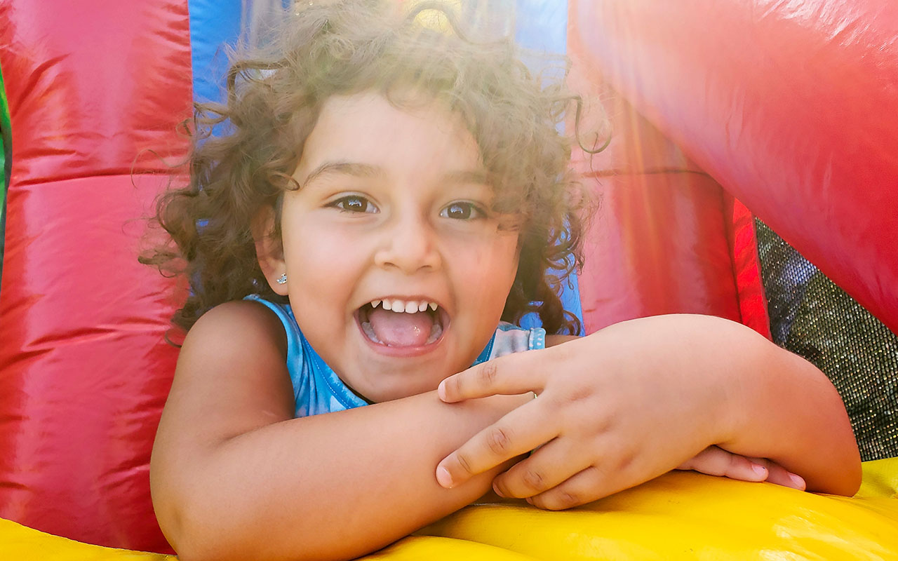 Smiling child enjoying a bright inflatable at a summer event, showcasing Water Slide Rentals in Travelers Rest, SC for family-friendly outdoor fun. Smiling child enjoying a bright inflatable at a summer event, showcasing Water Slide Rentals in Travelers Rest, SC for family-friendly outdoor fun.