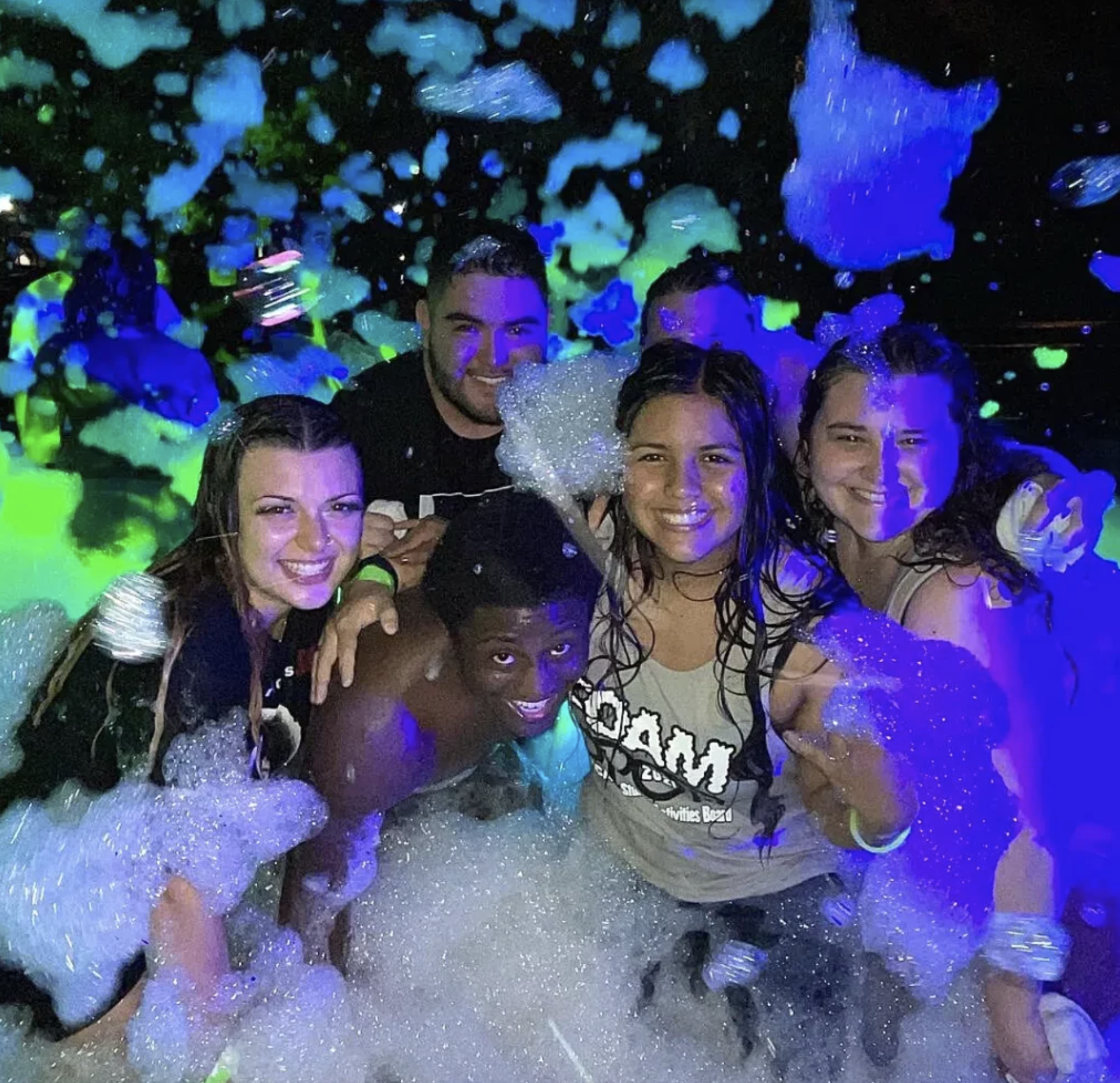 Group enjoying a nighttime foam party created by a high-output foam machine during an event in Wade Hampton SC.