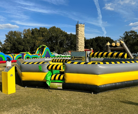 Inflatable mechanical wipeout game with yellow and black hazard design.