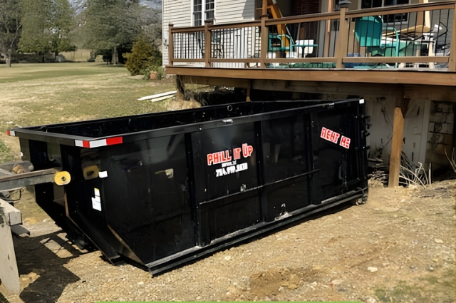 PHiLL It Up Disposal, LLC black dumpster next to a residential deck