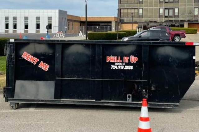 PHiLL It Up Disposal, LLC black dumpster on a city street