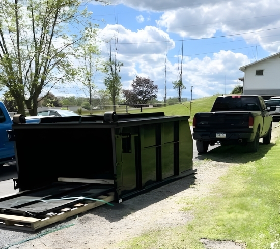 PHiLL It Up Disposal, LLC dumpster being hauled by a pickup truck on a sunny day