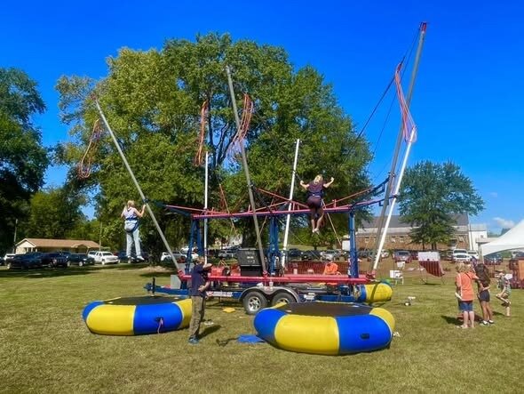 Euro bungee trampoline rental lifting jumpers at a Cleburne community event