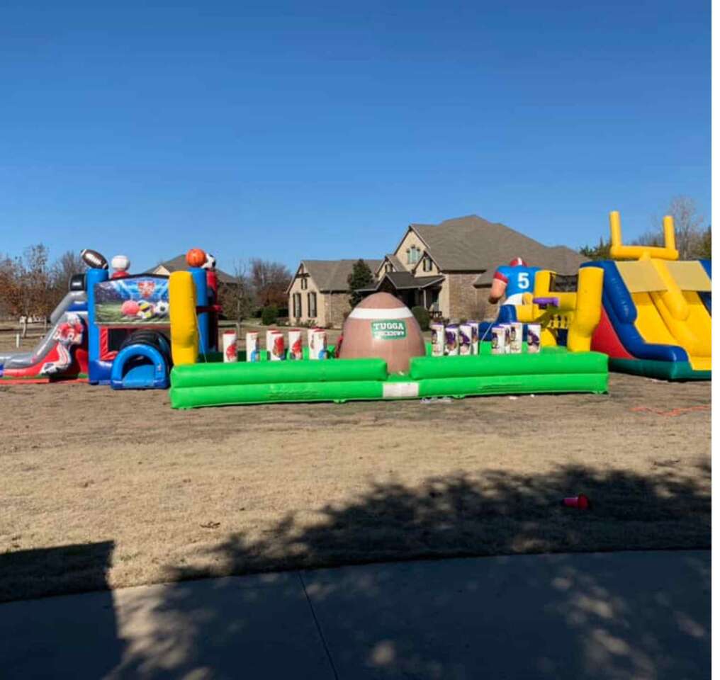 Birthday Party Rentals in Fort Worth for backyard parties showing a football jump house with slide and a interactive inflatable