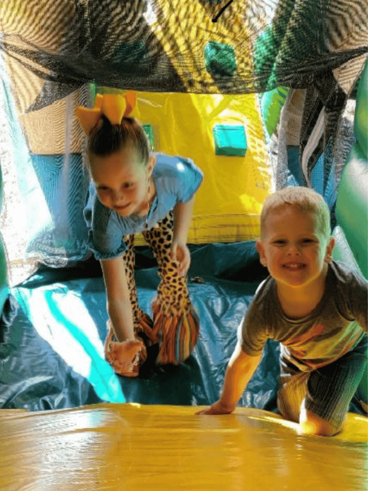 Inflatable bounce house and entertainment rentals in Granbury TX showing two kids having fun in a bo…