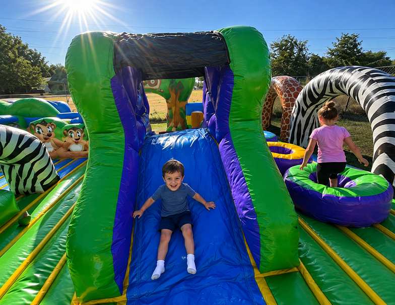 Toddler jump house rental with open top design set up in a DFW Texas backyard from Inflatable Party…