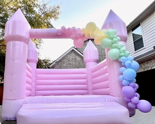 Pastel Pink Bounce House with Balloon Garland
