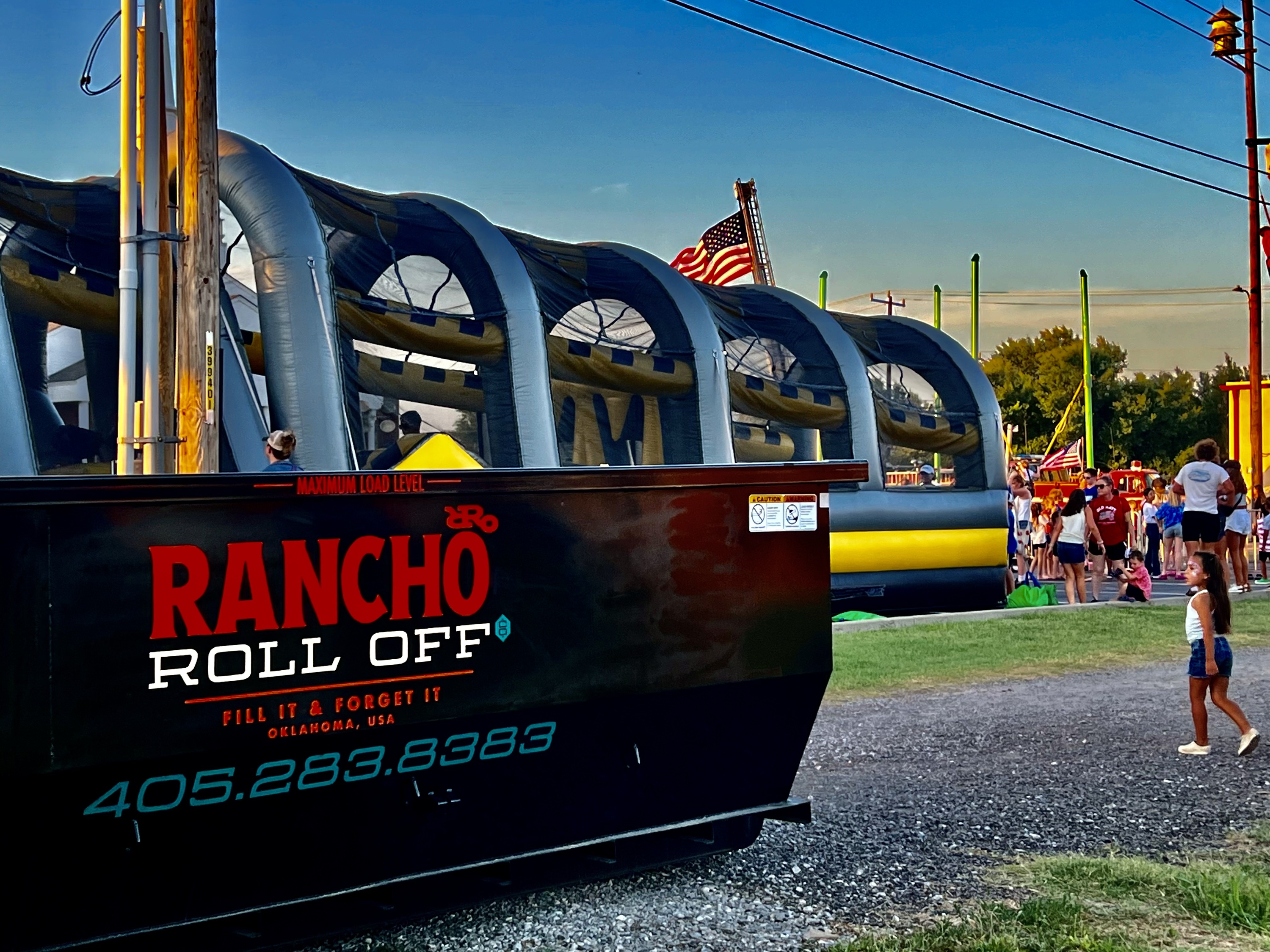 Rancho black dumpster in front of a bouncy house