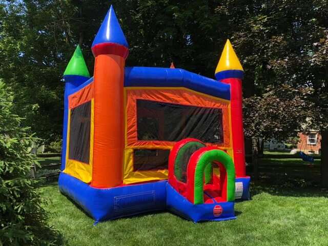 Colorful castle-themed bounce house rental from Party Go Round, set up in a sunny Maineville, OH backyard, ready to be the highlight for any child's party or gathering.